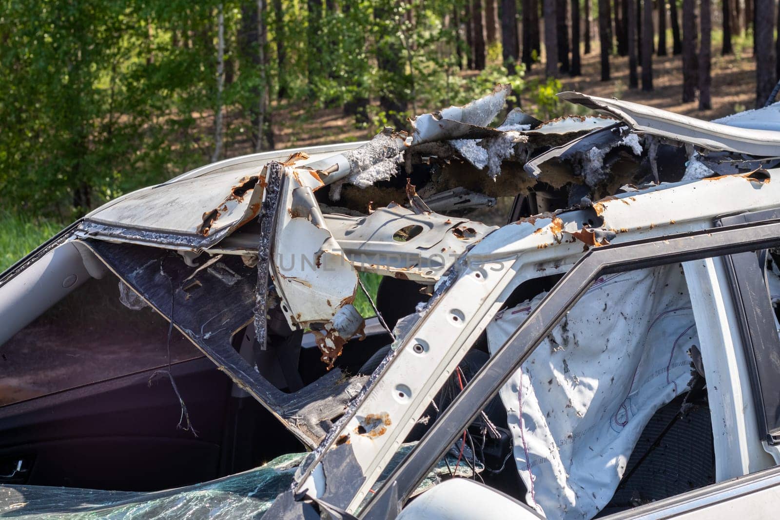 The remains of a civilian car, which was shot and destroyed by shell fragments. The actions of the Russian army during the evacuation of women and children during the Russian invasion of Ukraine