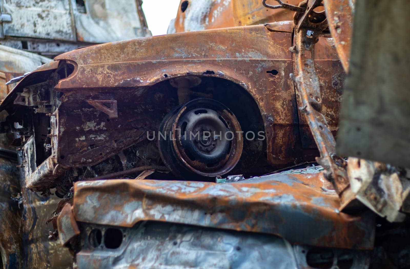 Broken and burned cars in the parking lot, accident or deliberate vandalism. Burnt car. Consequences of a car accident. Damaged by arson. Dump of civilian vehicles shot by Russian troops in Ukraine