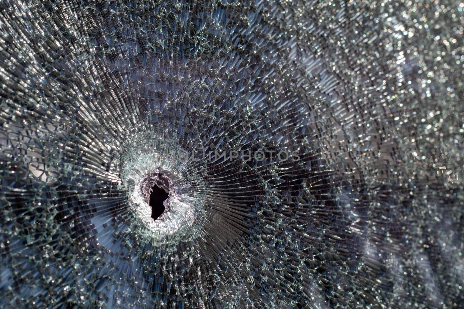 Holes on the windshield of the car, it was shot from a firearm. Bullet holes. Smash car windshield, broken and damaged car. The bullet made a cracked hole in the glass