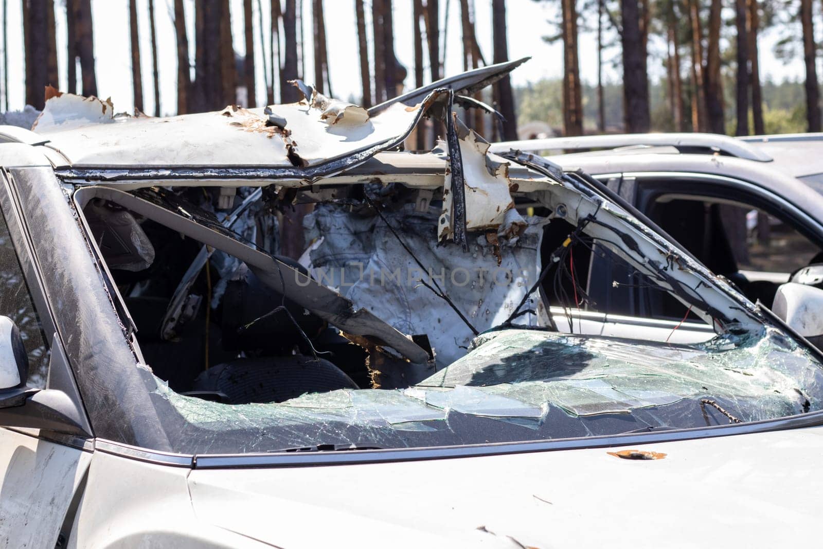 Shot car during the war in Ukraine. A car of civilians with shrapnel holes from explosions. Car accident. Car graveyard. Traces of shots on the body. The vehicle was damaged after the shelling