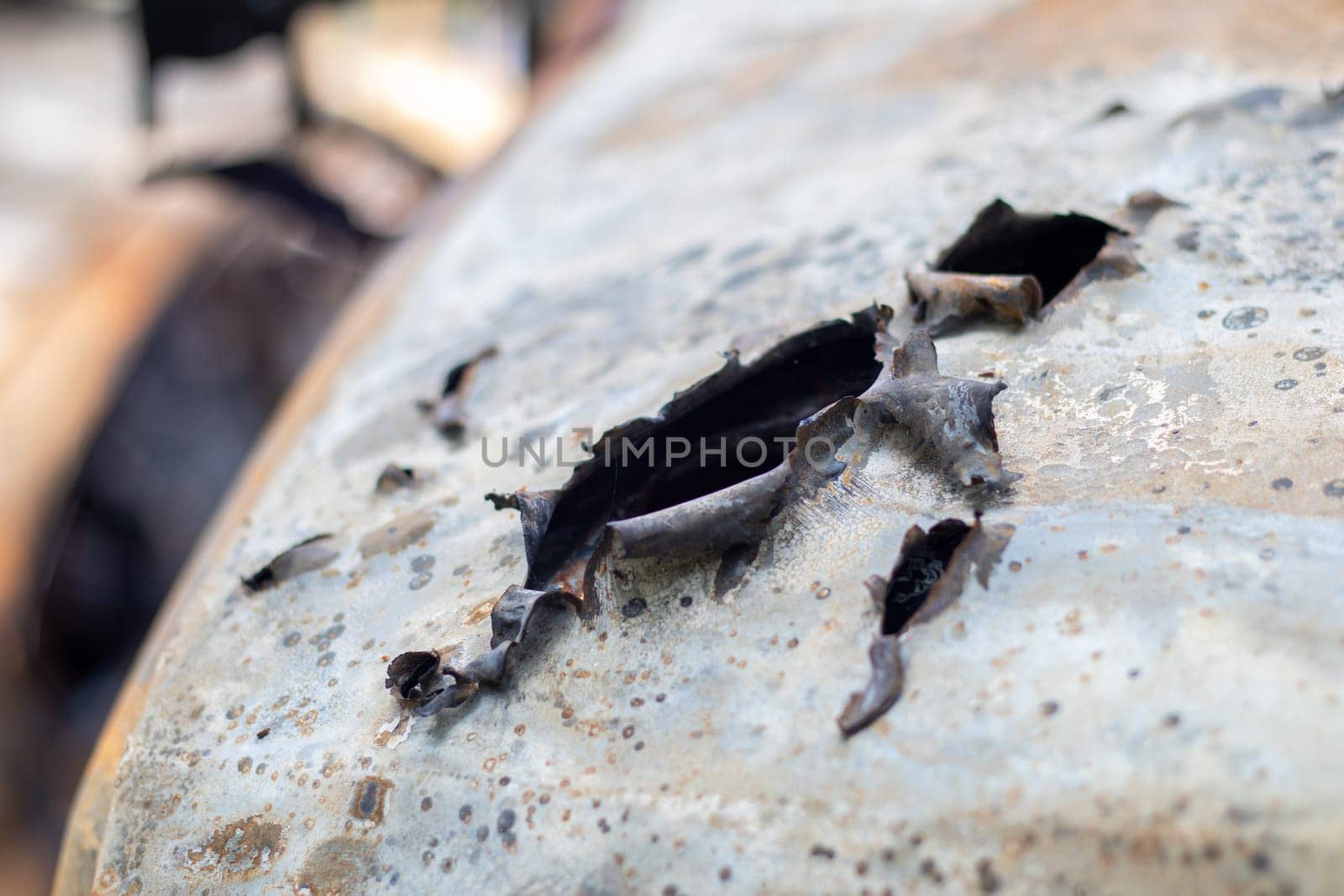 Burnt car body riddled with bullets. Russia's war against Ukraine. Shot by the Russian military car of civilians during the evacuation. Traces of bullets and fragments of shells
