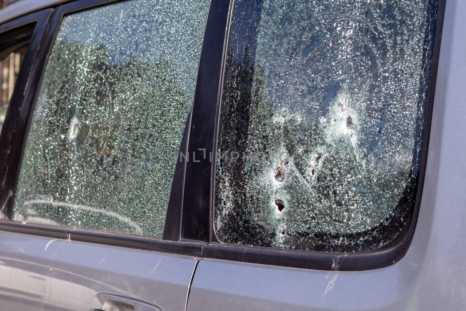 Traces of shots on the body of the car. War between Russia and Ukraine. Part of a civilian car that was fired upon during the evacuation of unarmed people from the combat zone