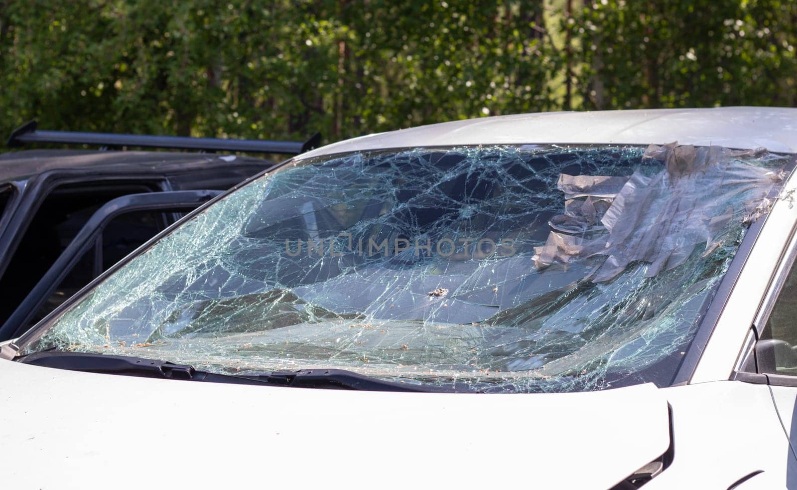 Close-up of a car with a broken windshield after a fatal crash. Consequence of a fatal car accident. Automobile danger. Reckless dangerous driving. Vehicle after an accident with a pedestrian