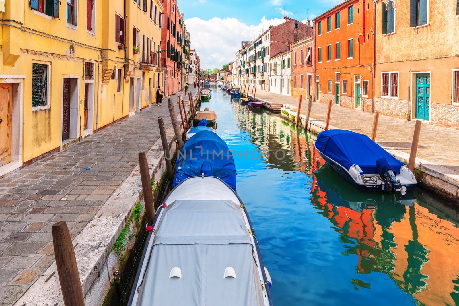 Boats moored near an italian street in the Grand Canal of Venice.