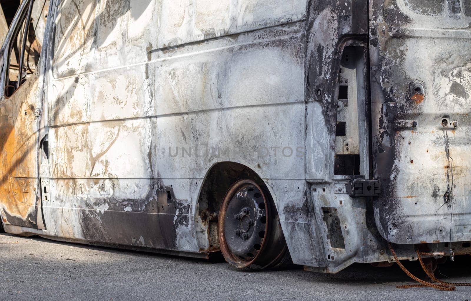 Cars after the fire. Iron parts of a burnt car. Burnt-out cars abandoned on the side of a quiet countryside. Explosion, the result of a fire. Car insurance concept. War of Russia against Ukraine