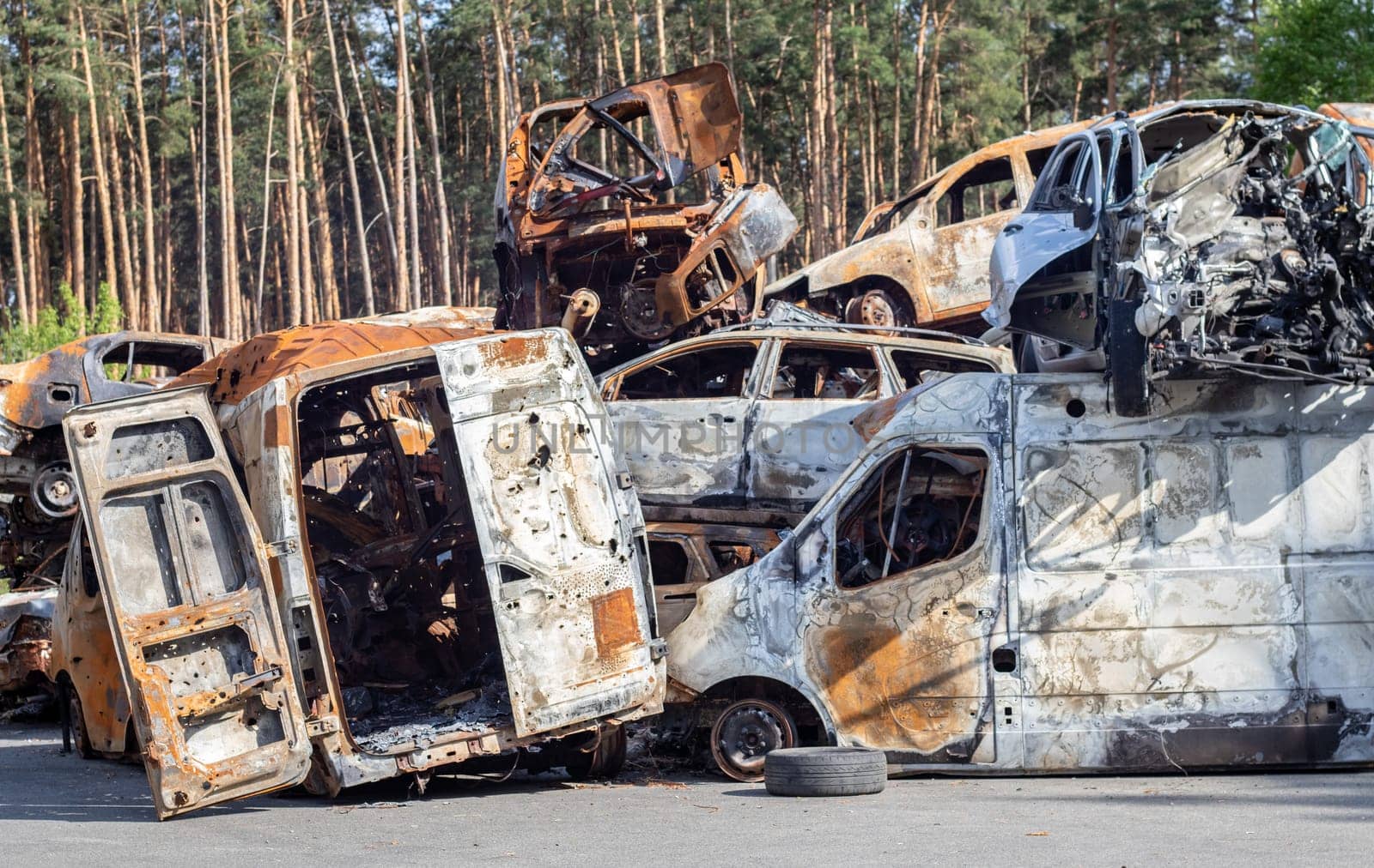 A lot of rusty burnt cars in Irpen, after being shot by the Russian military. Russia's war against Ukraine. Cemetery of destroyed cars of civilians who tried to evacuate from the war zone