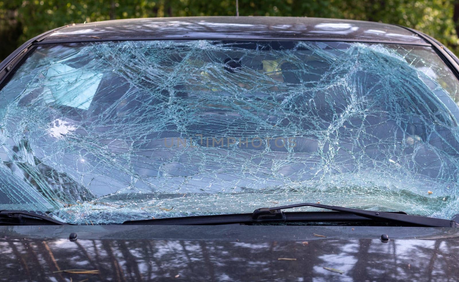 Close-up of a car with a broken windshield after a fatal crash. Consequence of a fatal car accident. Automobile danger. Reckless dangerous driving. Vehicle after an accident with a pedestrian