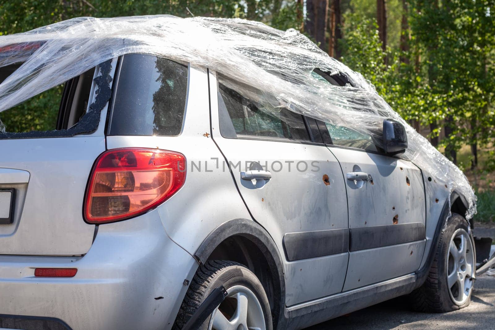 Shot, damaged cars during the war in Ukraine. The vehicle of civilians affected by the hands of the Russian military. Shrapnel and bullet holes in the body of the car. War of Russia against Ukraine