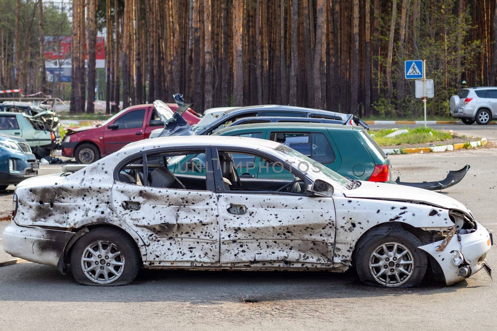 A car destroyed by shrapnel from a rocket that exploded nearby. Irpensky automobile cemetery. Consequences of the invasion of the Russian army in Ukraine. Destroyed civilian vehicle