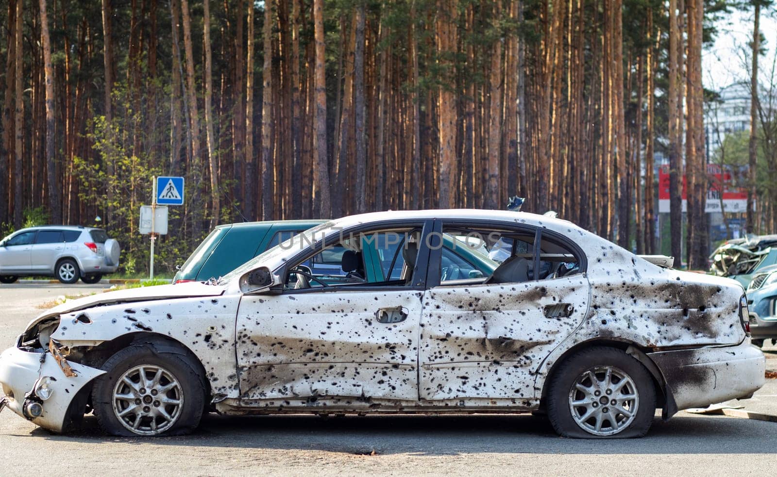 Shot, damaged cars during the war in Ukraine. The vehicle of civilians affected by the hands of the Russian military. Shrapnel and bullet holes in the body of the car. War of Russia against Ukraine