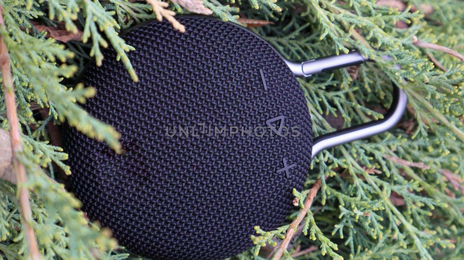 Waterproof round black Bluetooth speaker with carabiner. Digital music and audio concept. Mini, suitable for travel