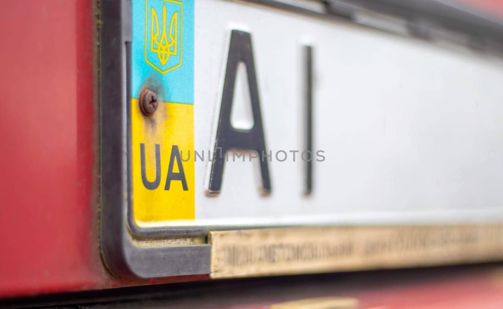 Ukrainian car registration number with national flag and coat of arms. Region code, Kyiv region AI, 10 region. Car number without numbers on the front bumper of the car, close-up