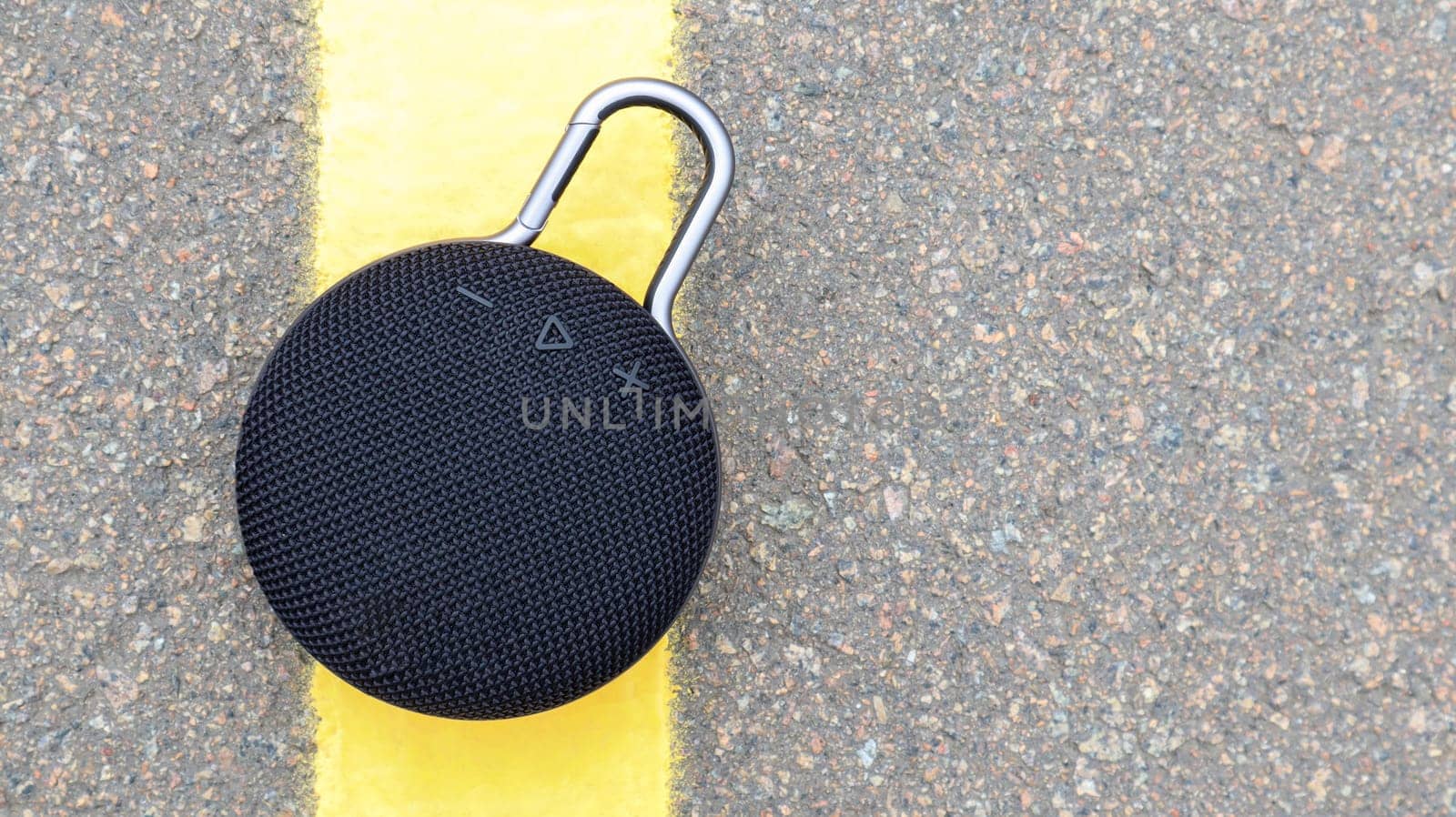 Waterproof round black Bluetooth speaker with carabiner. Digital music and audio concept. Mini, suitable for travel