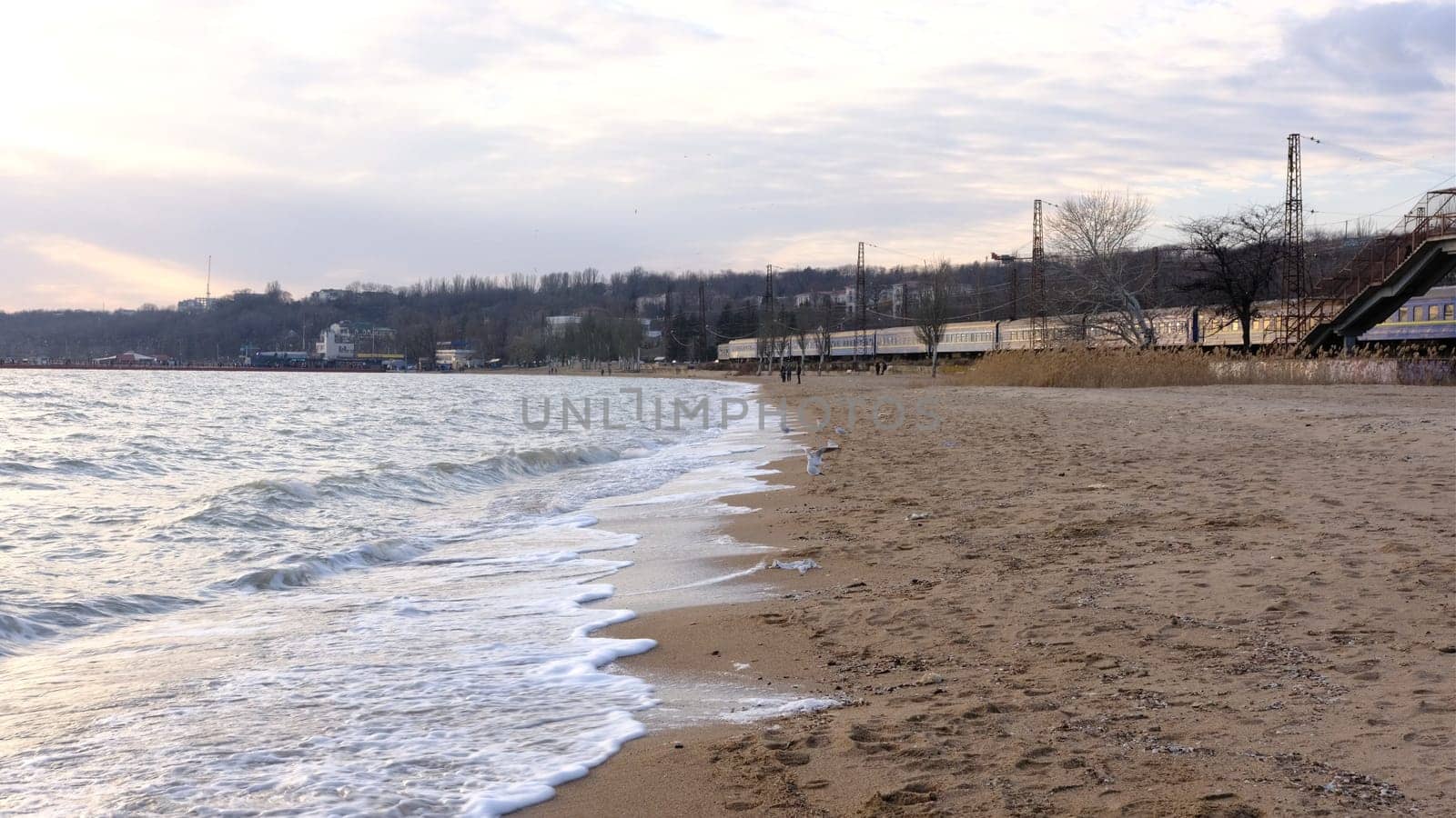Azov sea waves foam light breeze, sandy beach during day in summer in sun. close shot of raging sea at evening sunset. waves ocean beach sunset motion background. Nature Europe Ukraine water Azov sea