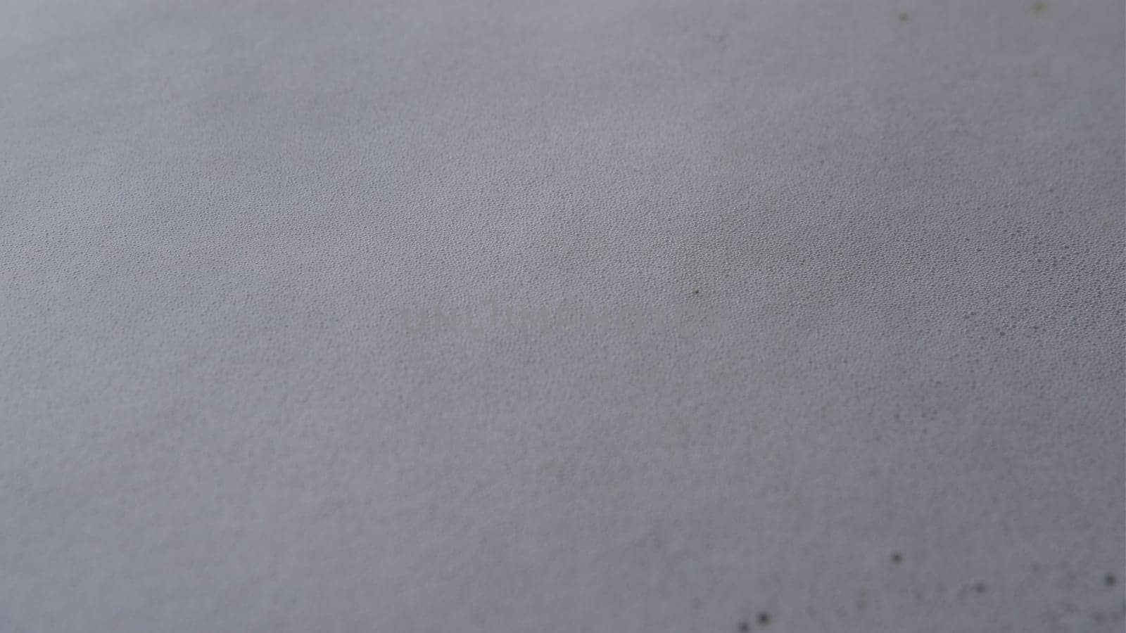 Steam or vapor clouds rising from boiling water with foam and watter bubbles. white and smooth surface.