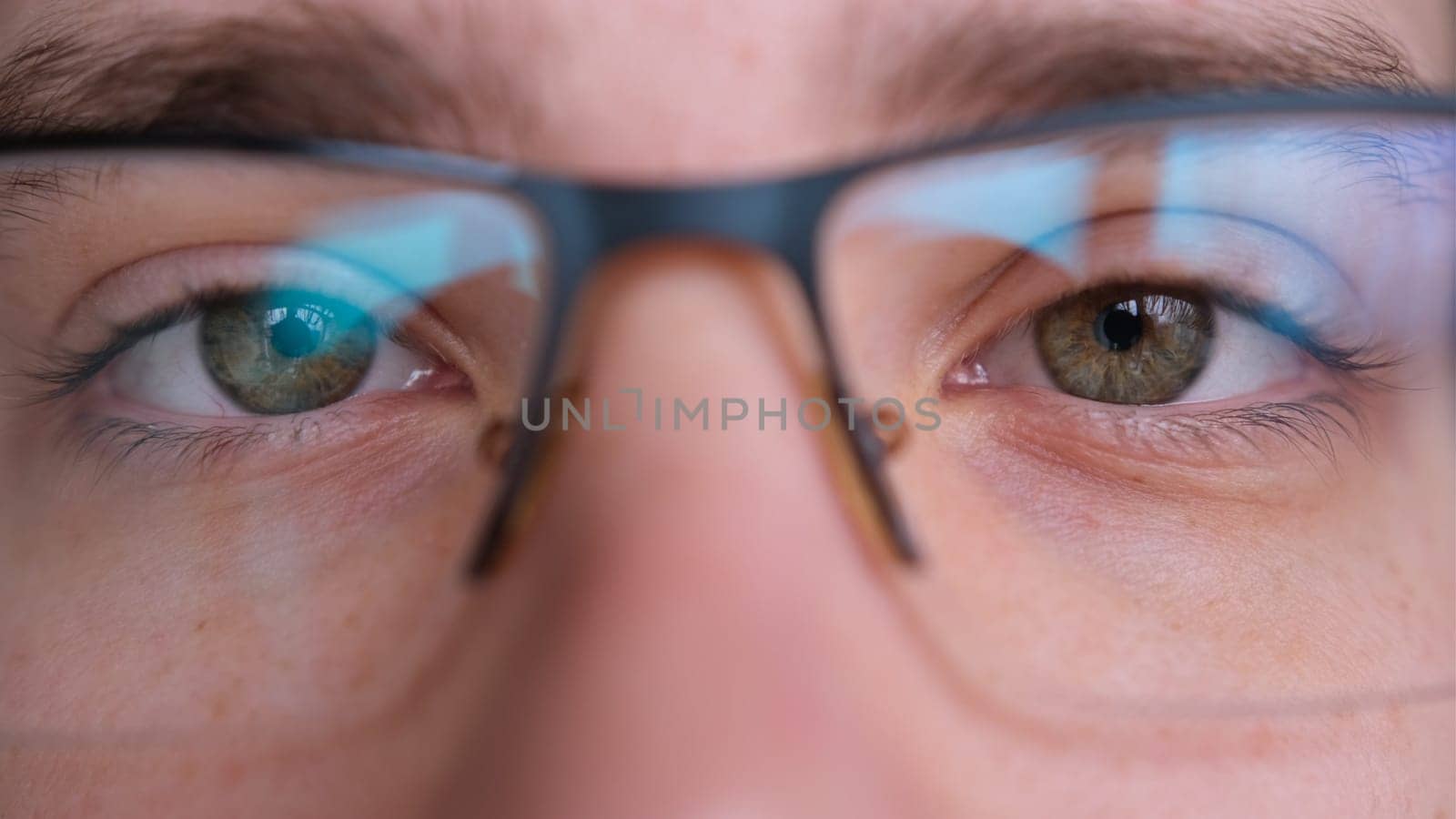 Close up of man's face with glasses. Boy opening his beautiful green eyes. European young male model with green eyes looking at camera. extreme close-up, 4K.