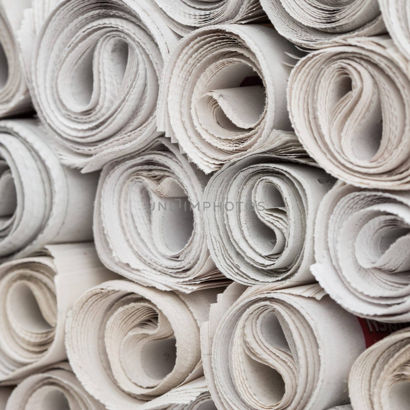 Stack of newspapers rolls, paper texture background.