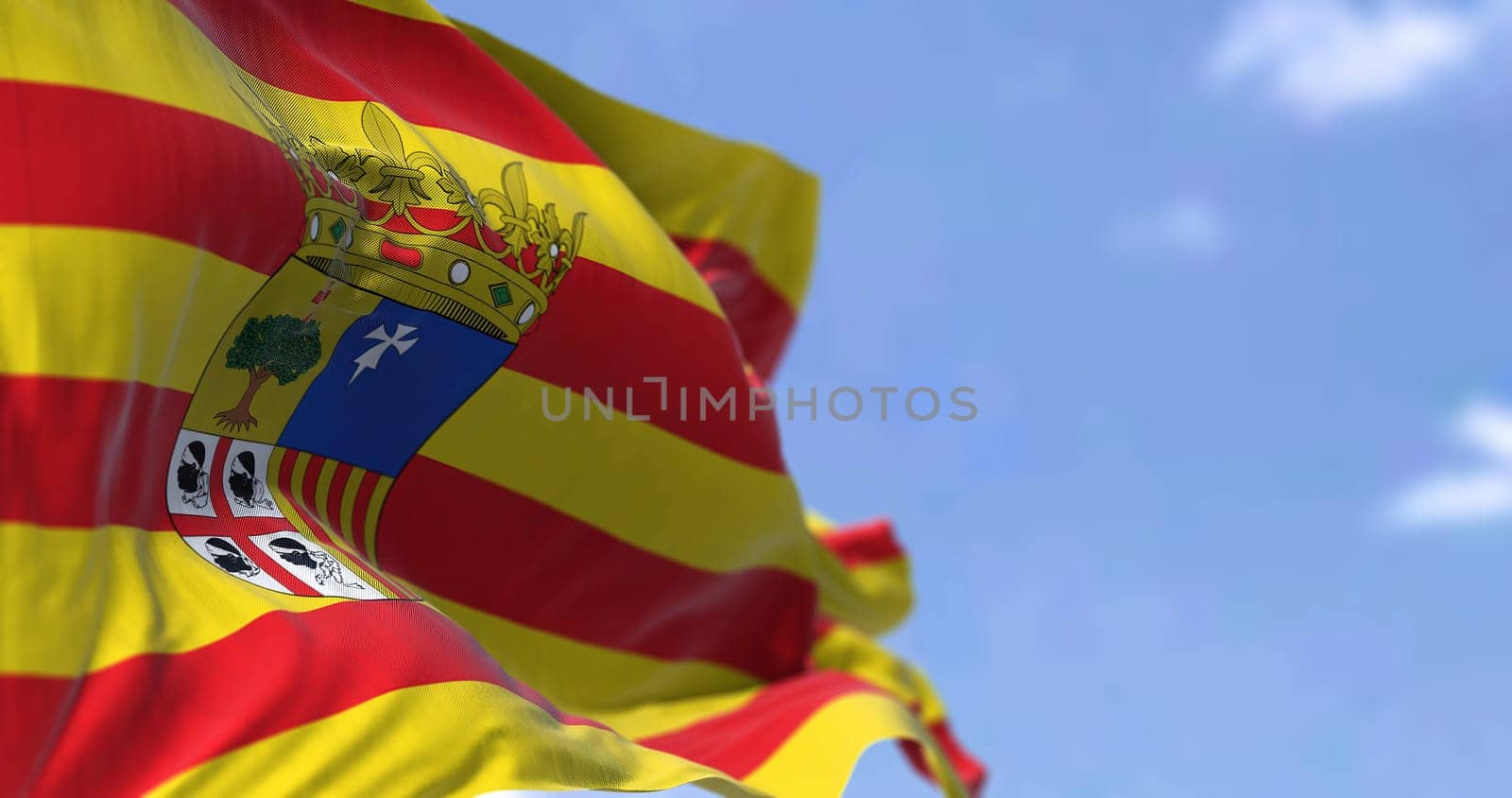 Aragonese flag waving in the wind on a clear day. Aragon is an autonomous community in Spain, coextensive with the medieval Kingdom of Aragon
