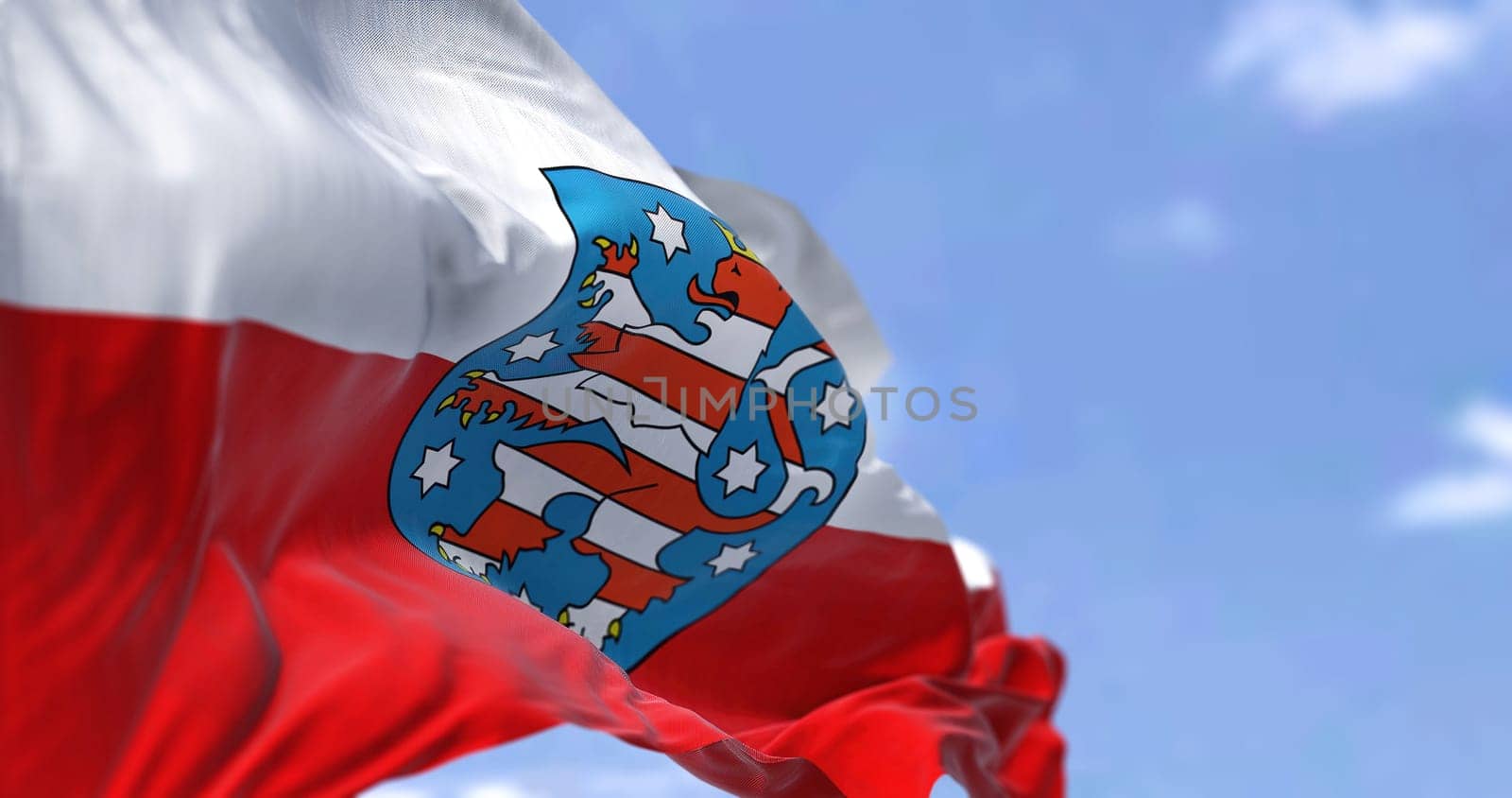The flag of Thuringia waving in the wind on a clear day. Thuringia is a German state (Land) situated in central Germany