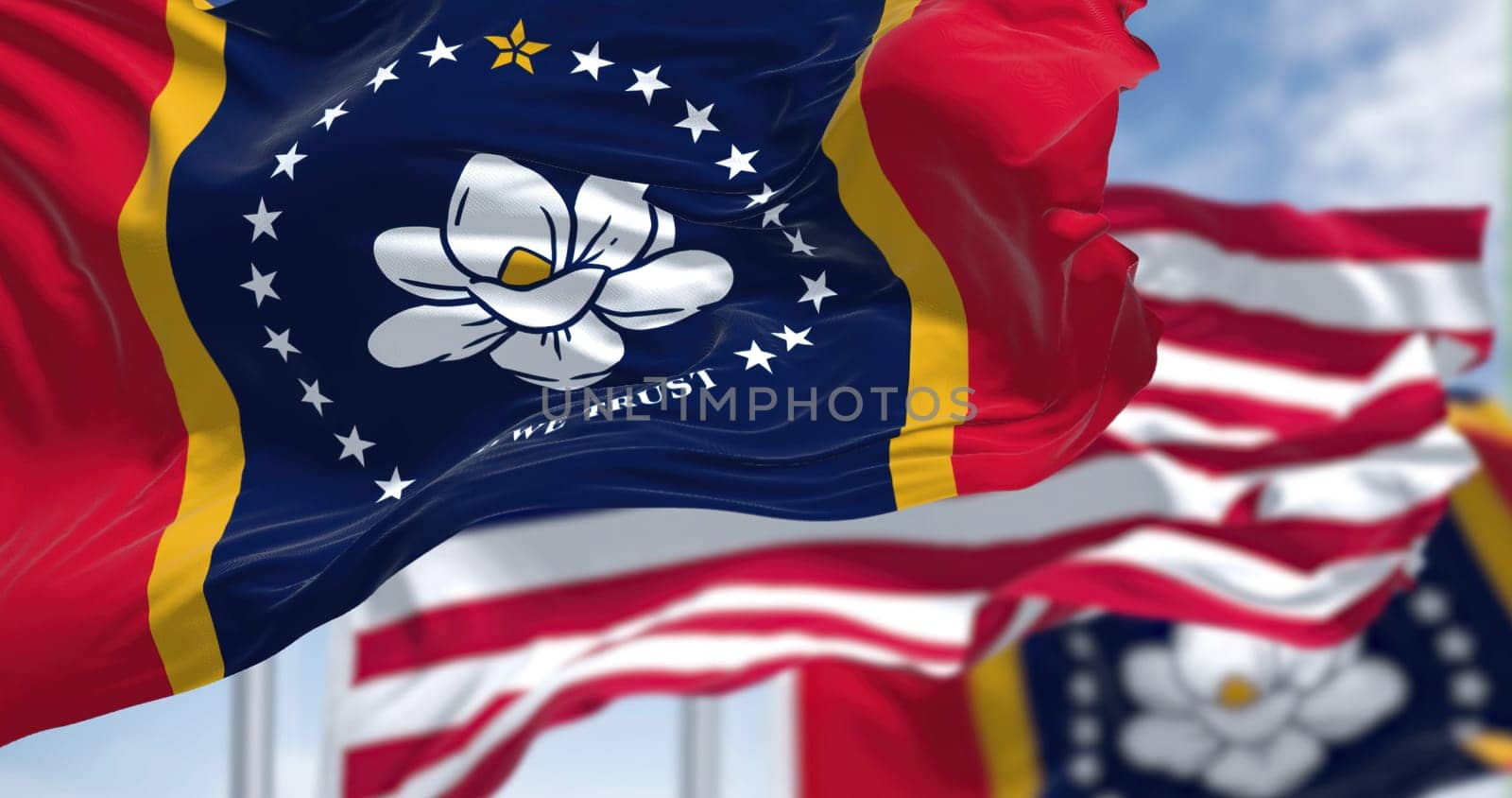 The Mississippi state flag waving along with the national flag of the United States of America. Mississippi is a state in the Southeastern region of the United States. Democracy and independence.