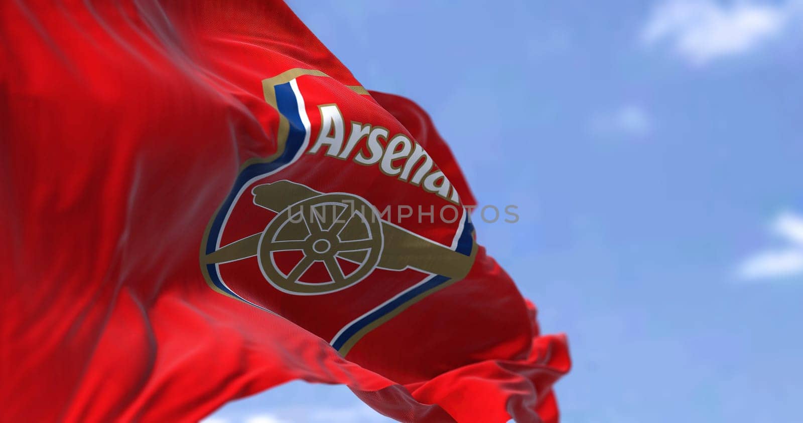 London, UK, May 2022: The flag of Arsenal Football Club waving in the wind on a clear day. Arsenal is a professional football club based in Islington, London, England