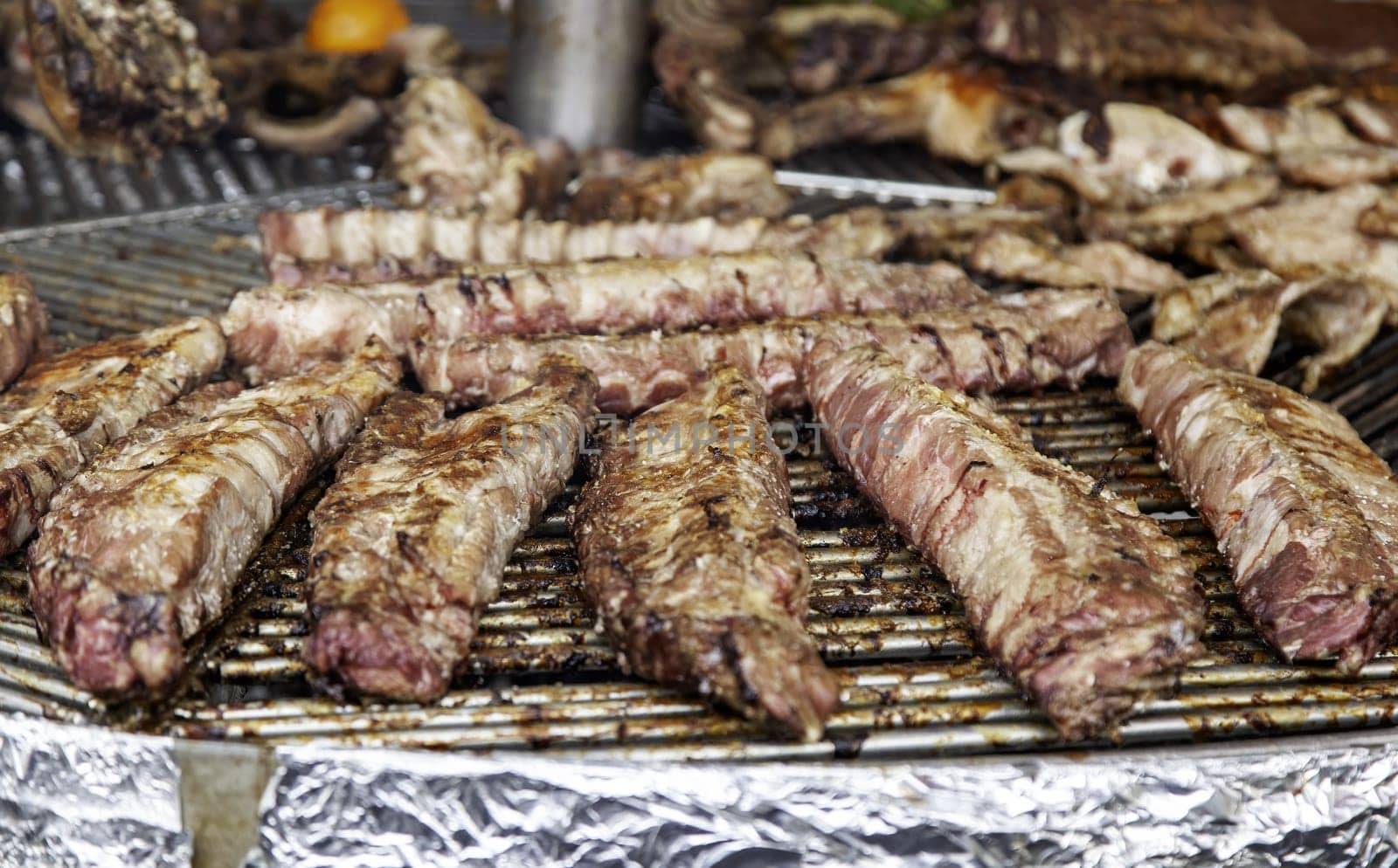 Detail of meat roasted on a charcoal grill, party and celebration