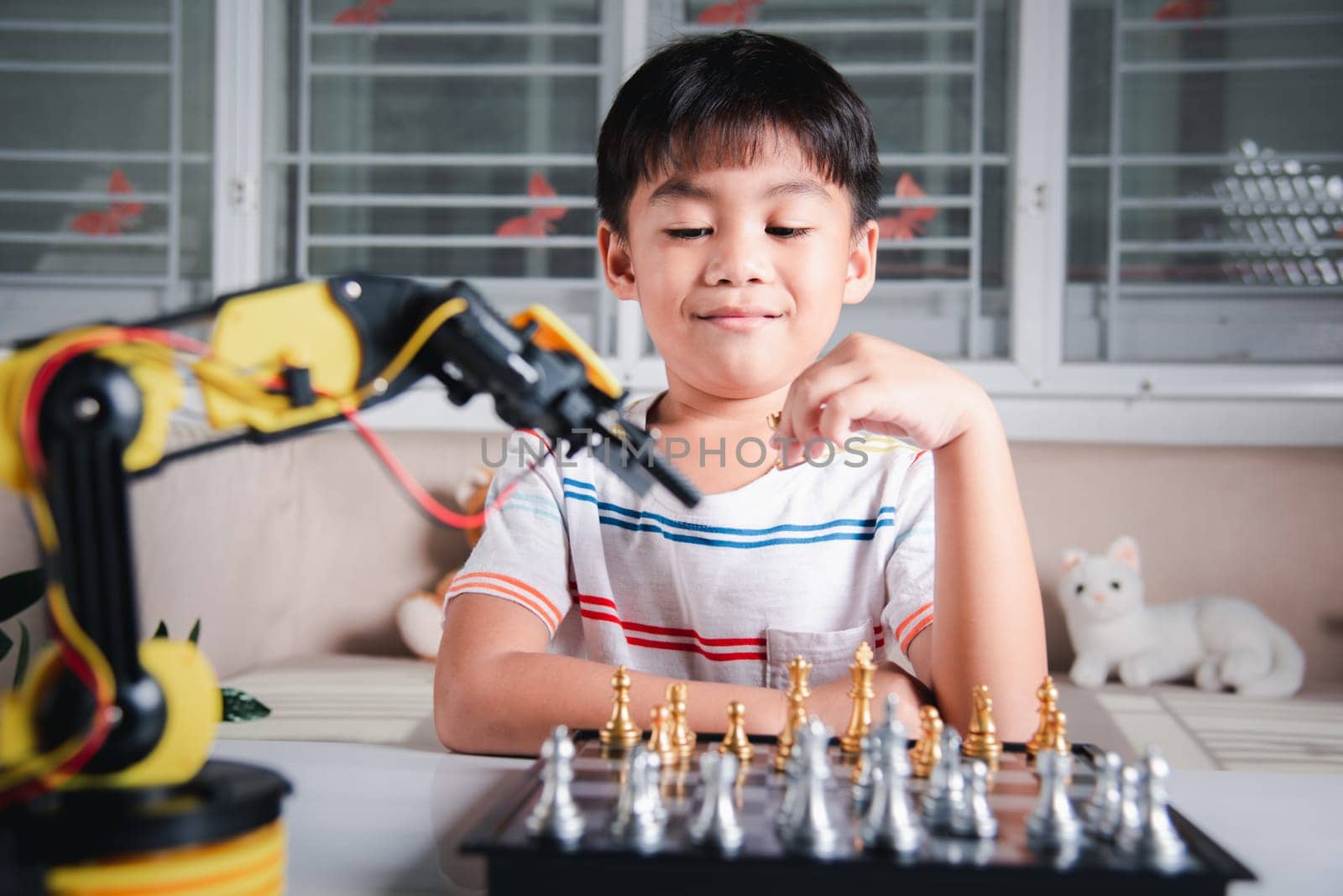 Asian little boy is playing chess with robot machine arm, STEM education E-learning, Funny children learning successful getting a lesson control robot arm, Technology science education concept