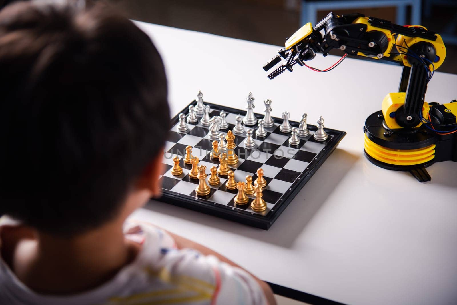 Asian little boy is playing chess with robot machine arm, STEM education E-learning, Funny children learning successful getting a lesson control robot arm, Technology science education concept