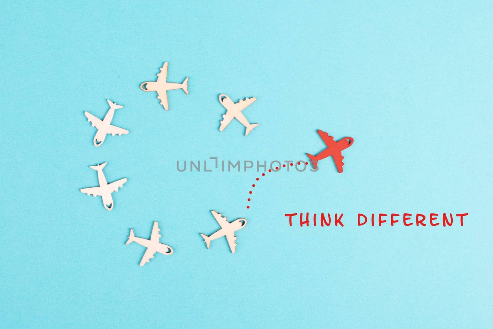 Group of airplanes flying in a circle, red plane thinks different and takes the opposite direction, against the stream symbolic, courage and winner concept
