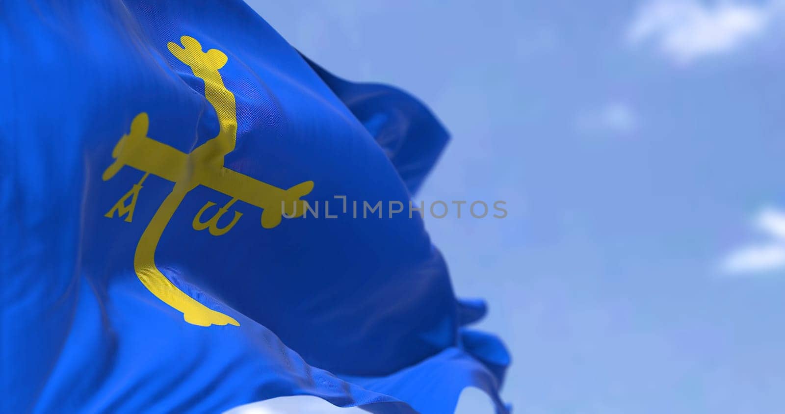 Rear view of the Asturias flag waving in the wind on a clear day. Asturias is an autonomous community in northwest Spain