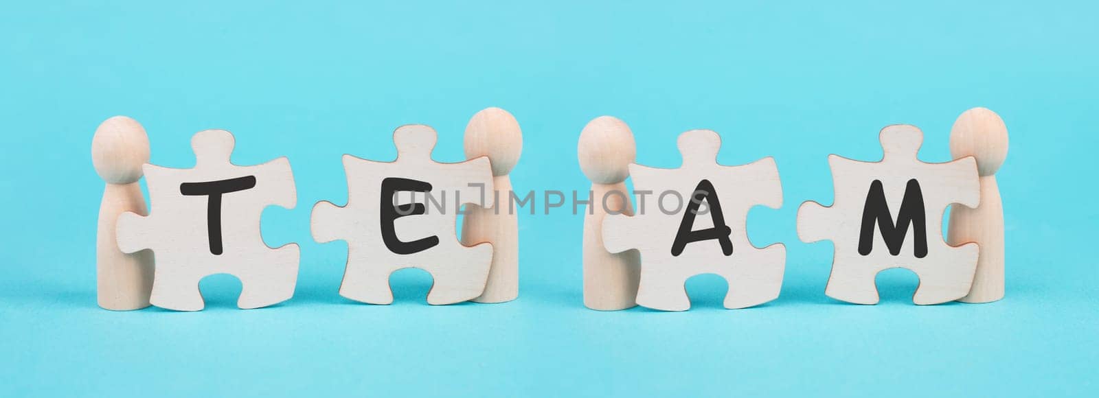 The word team is standing on puzzle pieces, connect the parts together, corporate in teamwork, communication and support concept