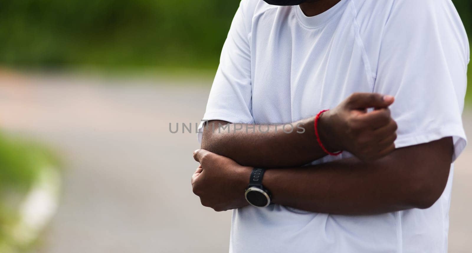 Close up Asian young sport runner black man wear watch he having elbow pain and use hands joint hold elbow while exercising at the outdoor street health park, healthy exercise Injury from workout