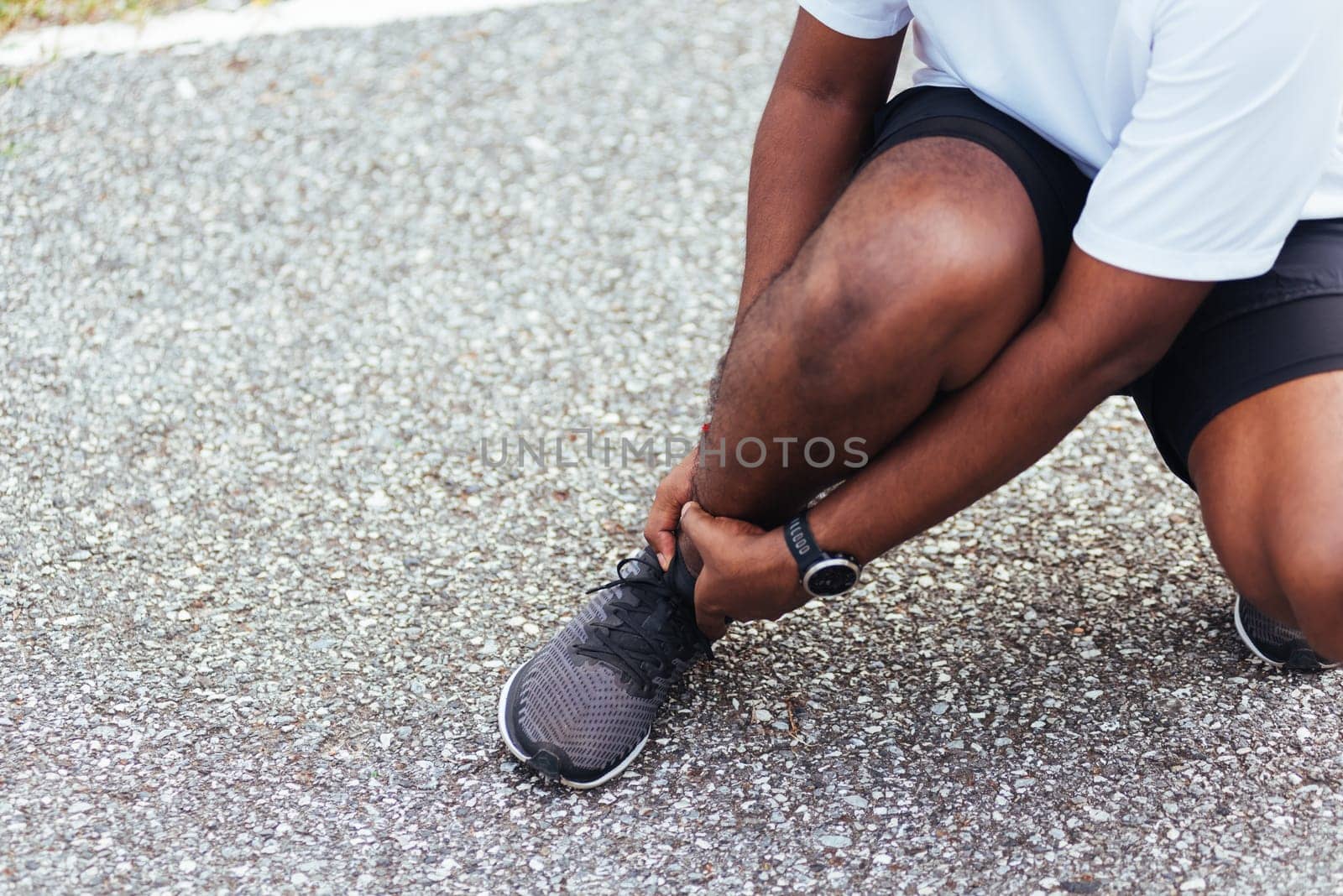 Close up Asian young sport runner black man wear watch hands joint hold leg pain because of twisted ankle broken while running at the outdoor street health park, healthy exercise Injury from workout