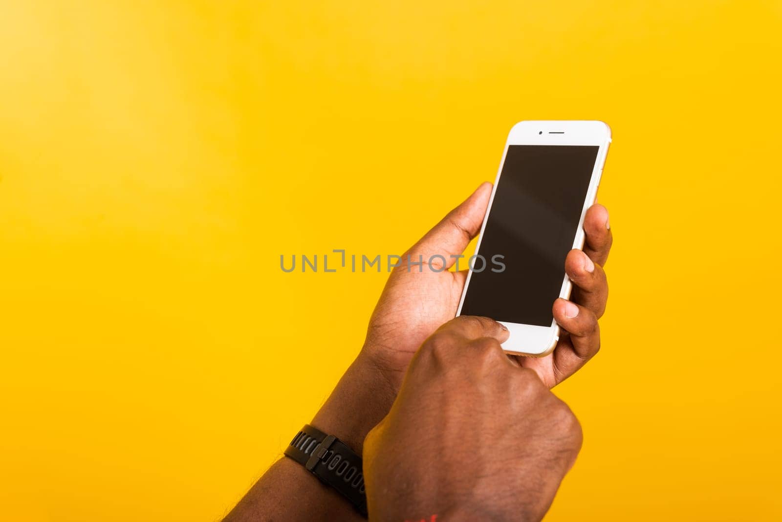 Closeup Asian happy portrait young black man holding digital mobile smartphone blank screen space on hands, studio isolated on yellow background