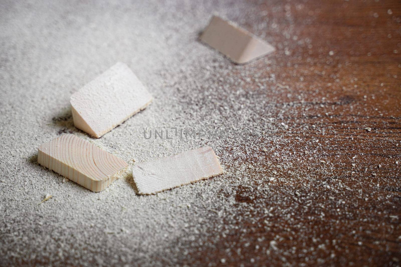 closeup of cut pieces of wood with sawdust on brown wooden floor