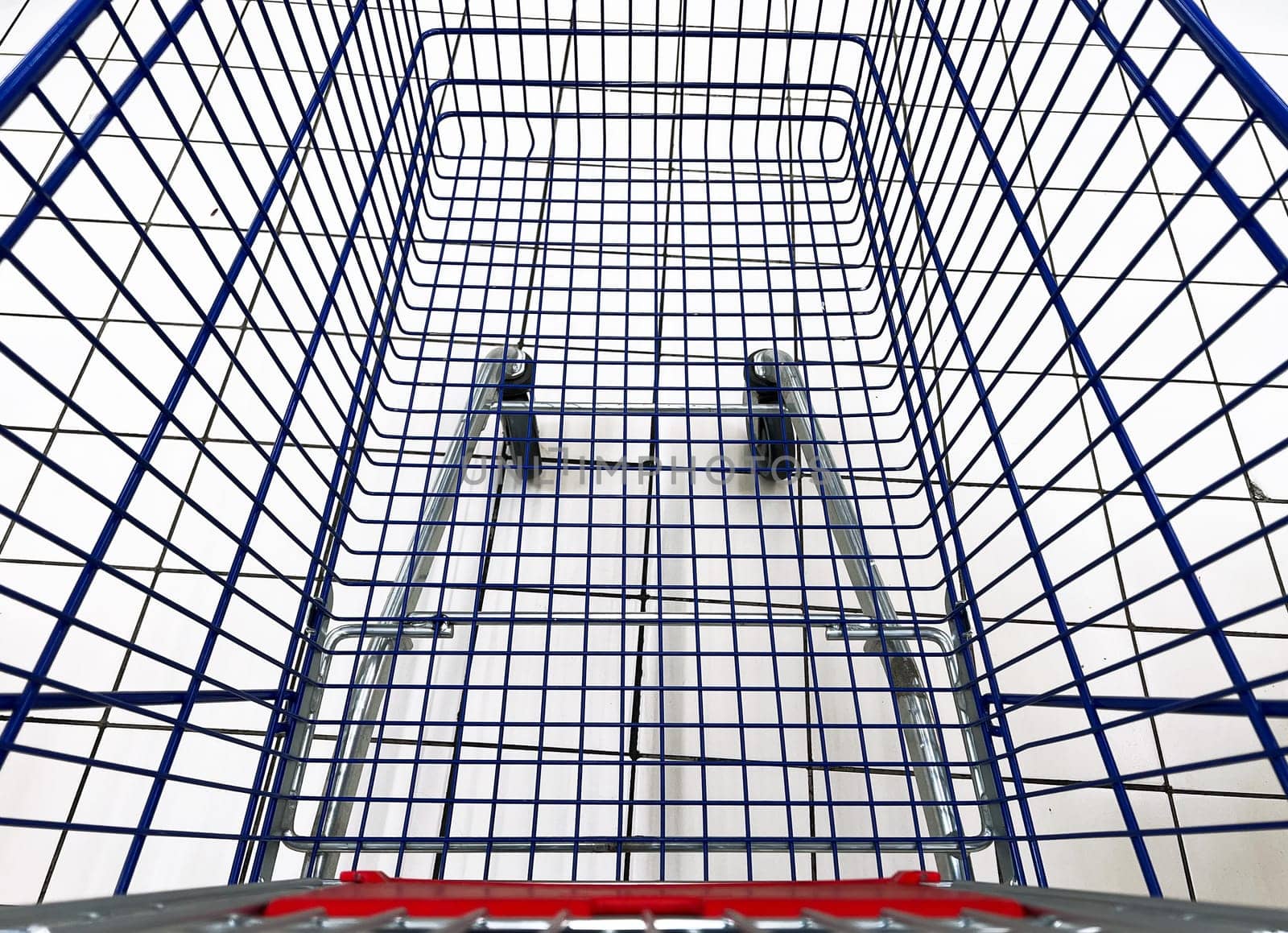 top view closeup of empty metallic shopping cart in supermarket