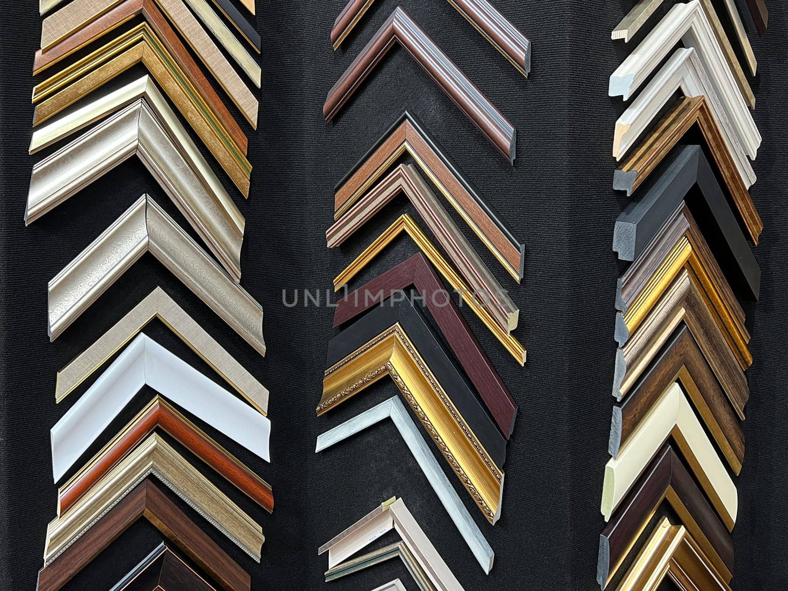 many picture and painting art wooden frame samples in different sizes and color exhibited on a black wall