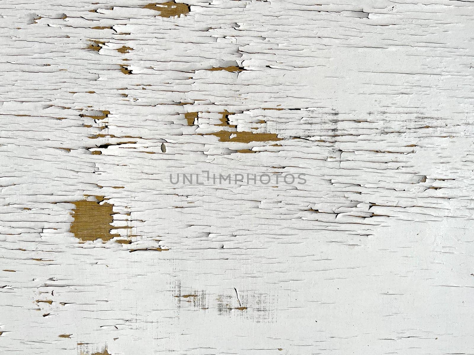 top view closeup of weathered white peeled painted wood plank background with signs of heavy wear