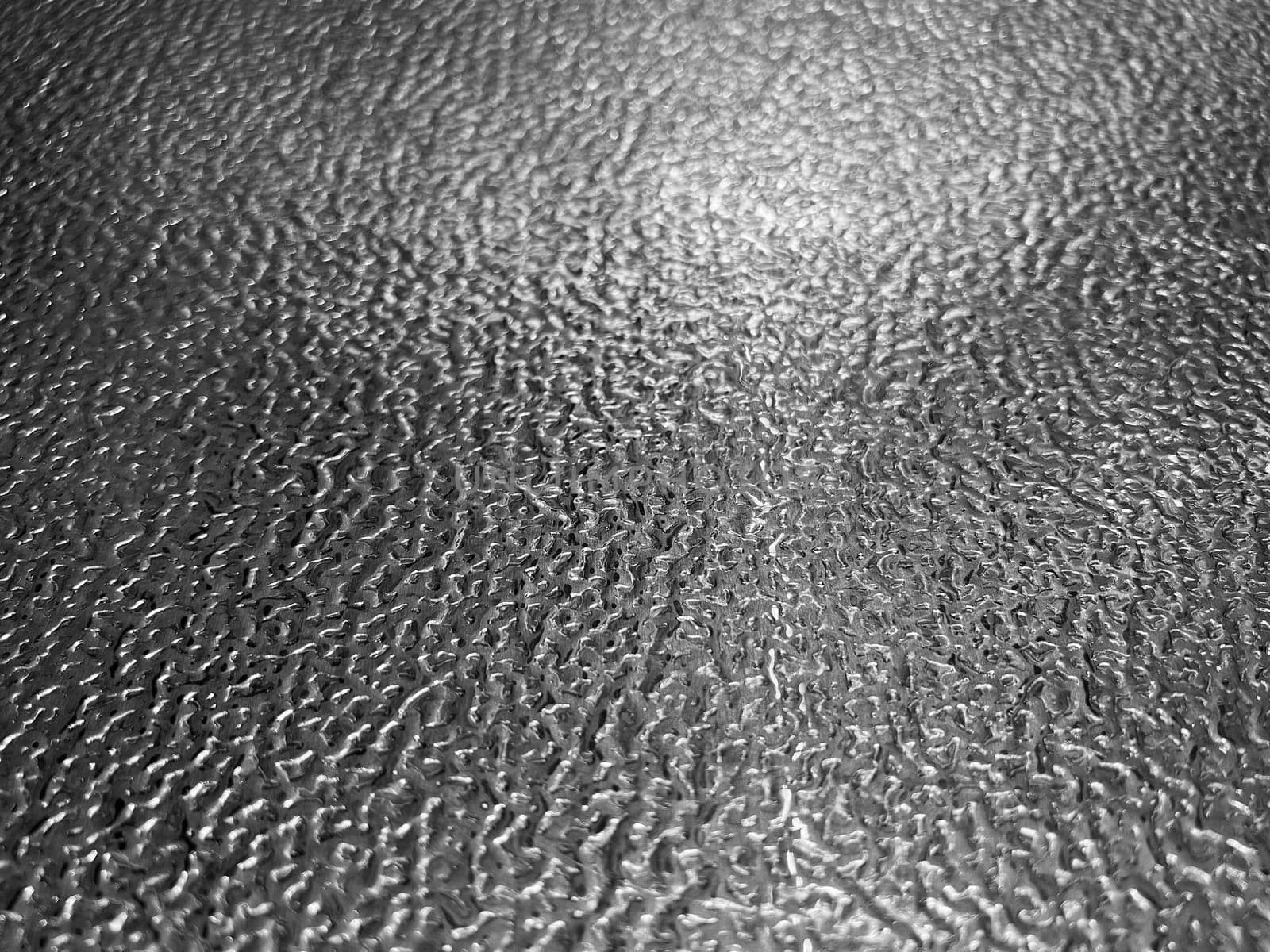 front view closeup of stainless steel plate metal flooring with embossed metallic pattern and shallow depth of field