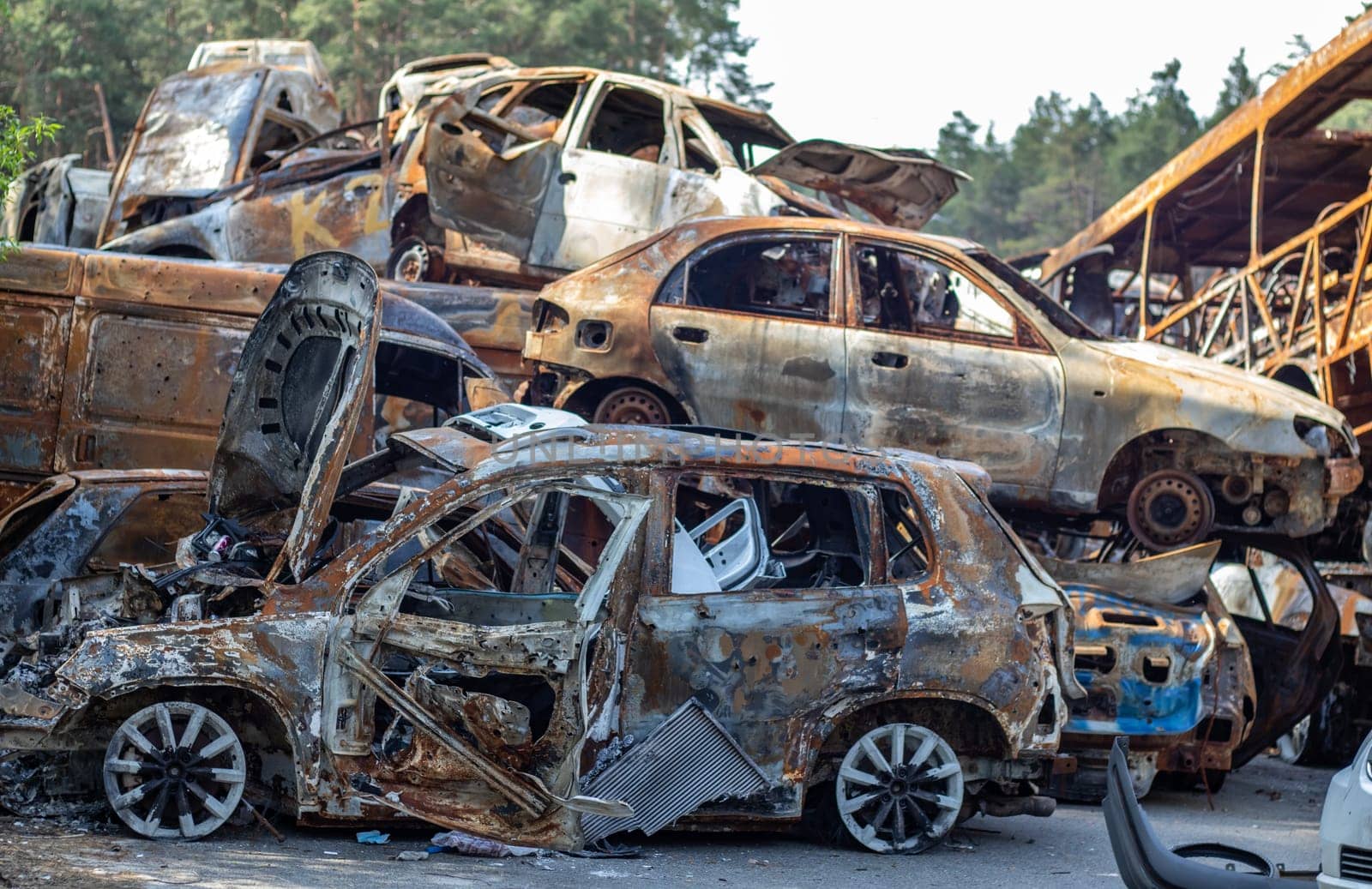 A lot of rusty burnt cars in Irpen, after being shot by the Russian military. Russia's war against Ukraine. Cemetery of destroyed cars of civilians who tried to evacuate from the war zone