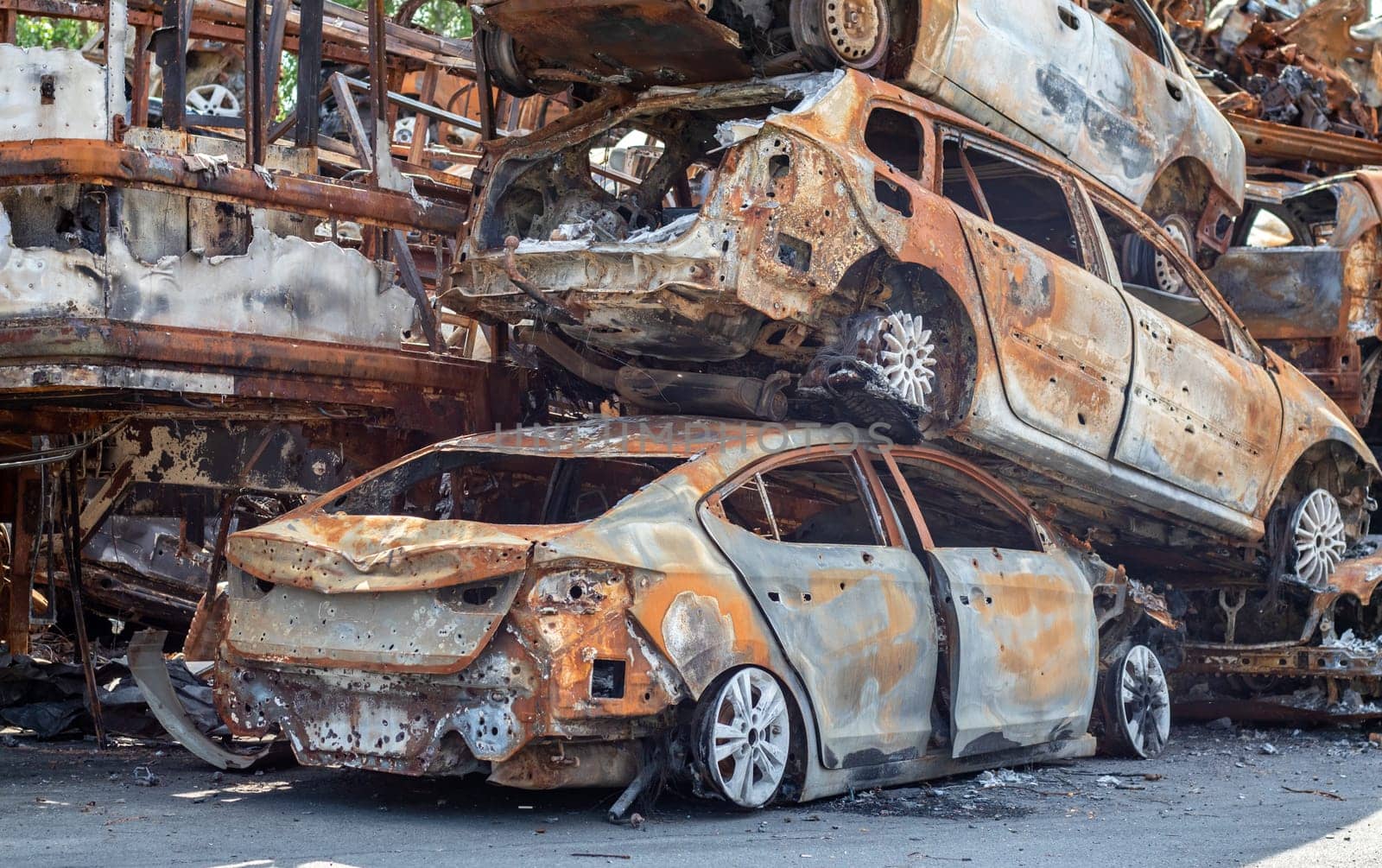 A lot of rusty burnt cars in Irpen, after being shot by the Russian military. Russia's war against Ukraine. Cemetery of destroyed cars of civilians who tried to evacuate from the war zone