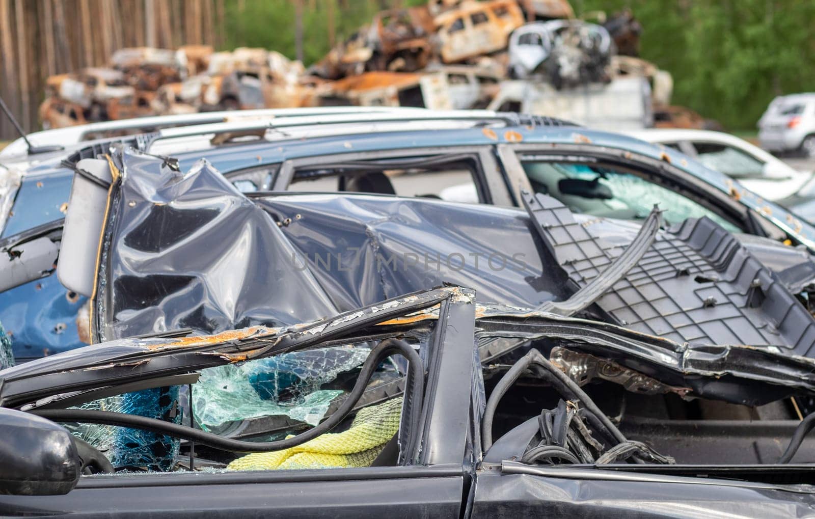 Dump of shot civilian cars by Russian invaders in Ukraine. The remains of cars that were shot and destroyed by shell fragments. War of Russia against Ukraine. Car graveyard