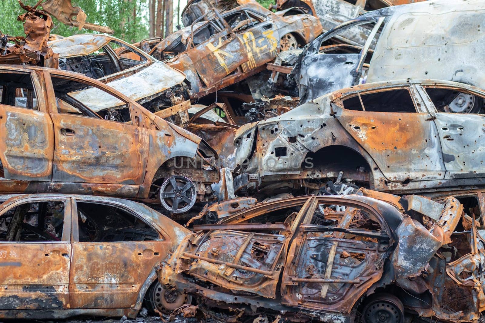 A lot of rusty burnt cars in Irpen, after being shot by the Russian military. Russia's war against Ukraine. Cemetery of destroyed cars of civilians who tried to evacuate from the war zone