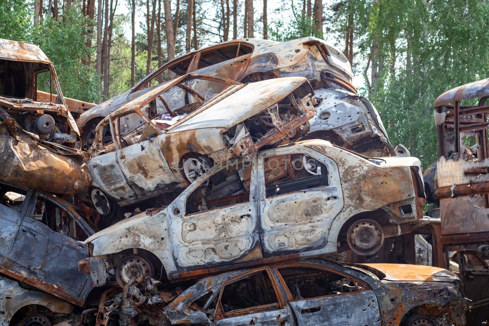 Russian invasion of Ukraine in 2022, destroyed and burned cars. Cars were beaten with shrapnel and burned. Irpensky automobile cemetery. The consequences of the war in a peaceful city near Kyiv