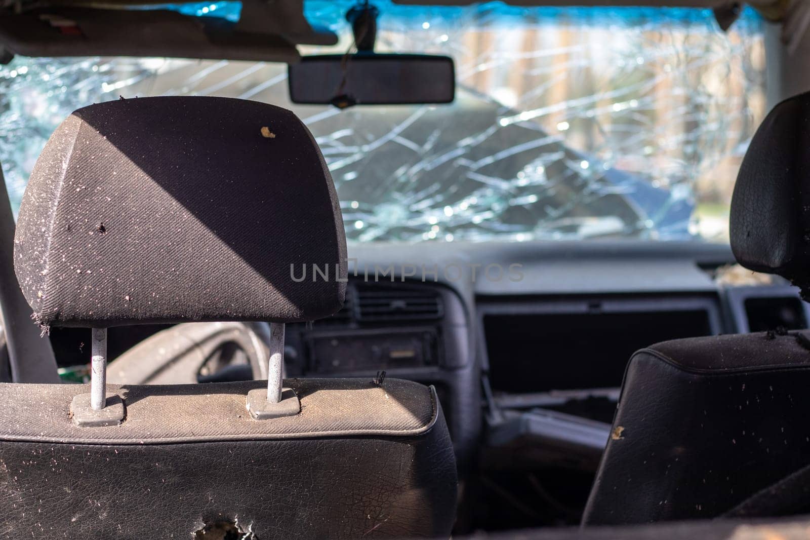Damaged car window after an accident. Broken windshield as a result of an accident, inside view. Cabin interior details, view from the cab. Safe movement. Broken windshield. Glass crack and damage