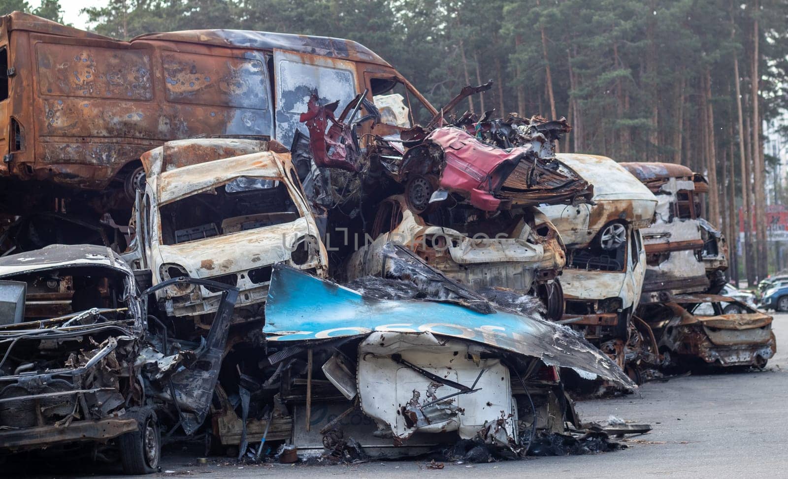 Rusty burnt cars destroyed by rocket explosions. War in Ukraine. Destroyed vehicles of civilians who were leaving were evacuated from the combat zone from Bucha and Irpin. Car graveyard