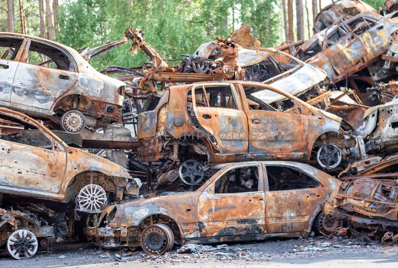 Rusty burnt cars destroyed by rocket explosions. War in Ukraine. Destroyed vehicles of civilians who were leaving were evacuated from the combat zone from Bucha and Irpin. Car graveyard