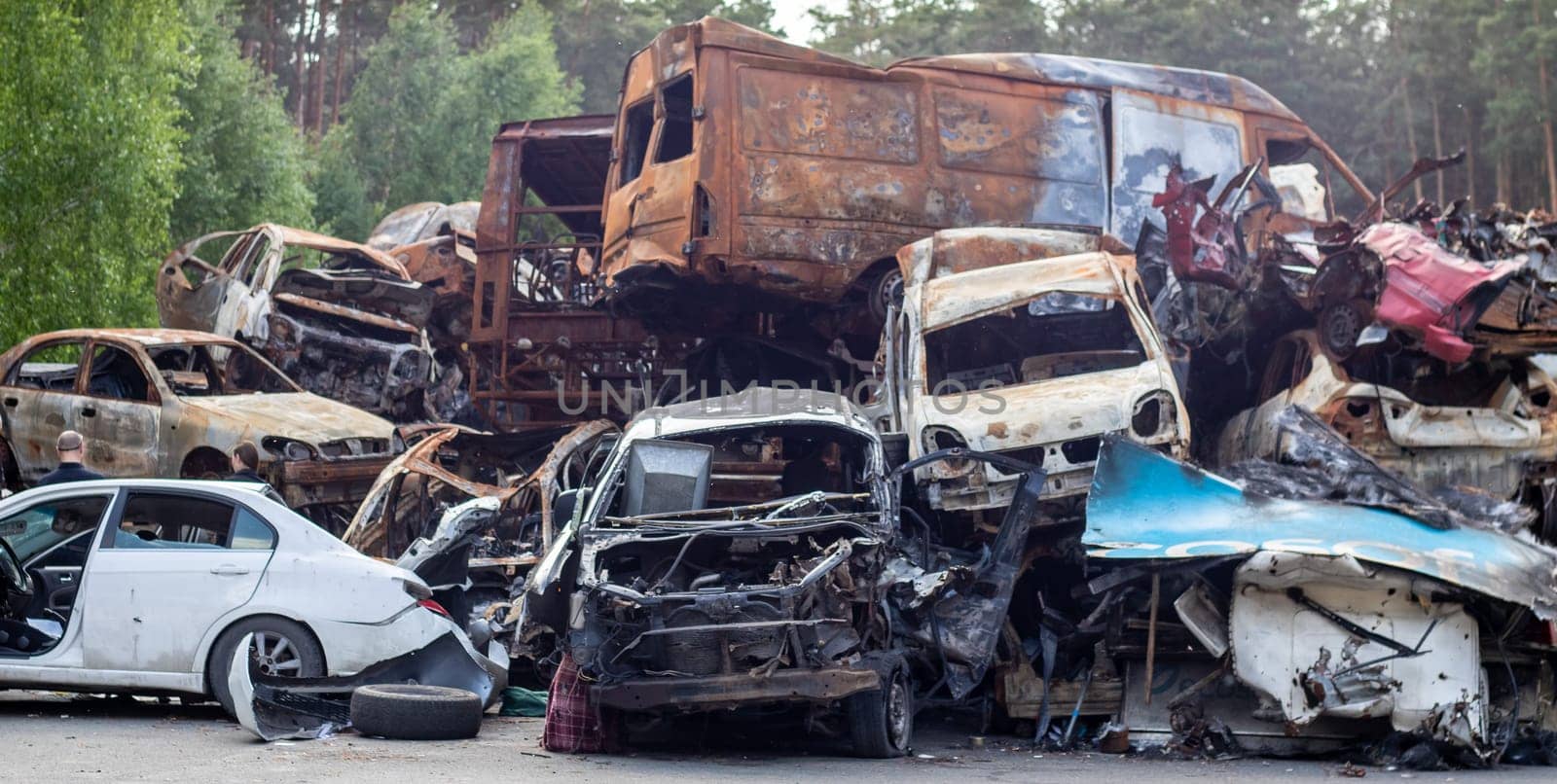 A lot of rusty burnt cars in Irpen, after being shot by the Russian military. Russia's war against Ukraine. Cemetery of destroyed cars of civilians who tried to evacuate from the war zone
