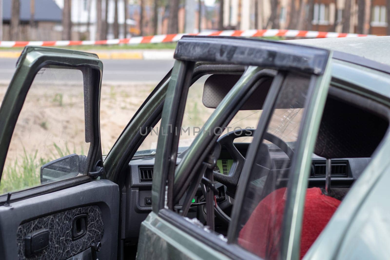 Criminal incident. Breaking into a car parked on the street. Broken side glass and the passenger compartment behind it. A crime committed by a thief, stealing things. Car after an accident