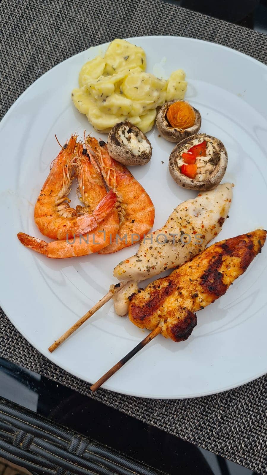 Grilled meat on wooden skewers on plate. Top view, lying flat